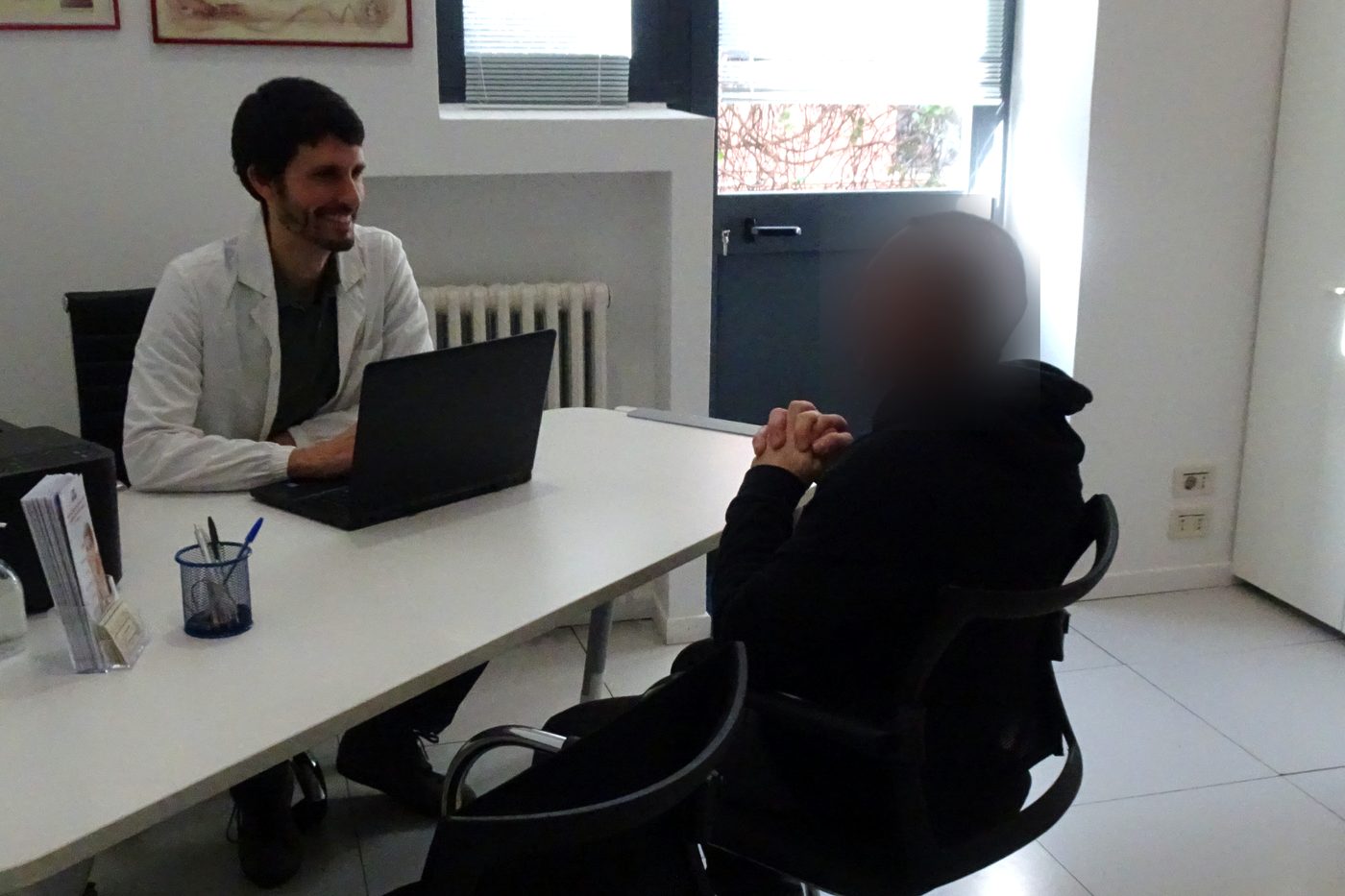 Il dottor Locatelli durante un colloquio con un paziente nel suo studio